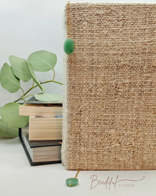 Image of the Elyria bookmark which simply has a faux jade pendant attached to each end of a long stainless steel chain. It is used inside the spine of the book with the two ends dangling outside to mark the place of the book.