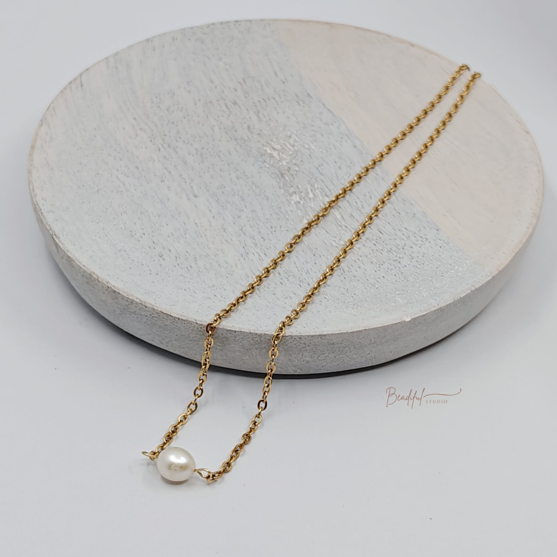 Image of the necklace laying flat on  a wooden plate