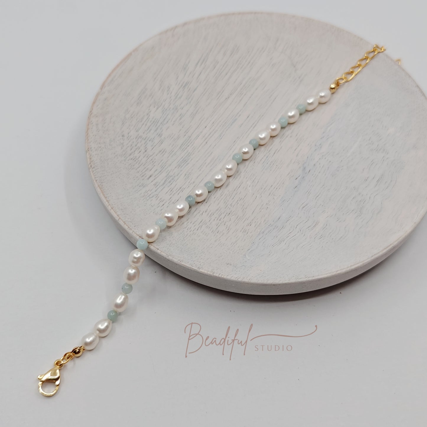 Picture of the bracelet stretched across a small beige plate.