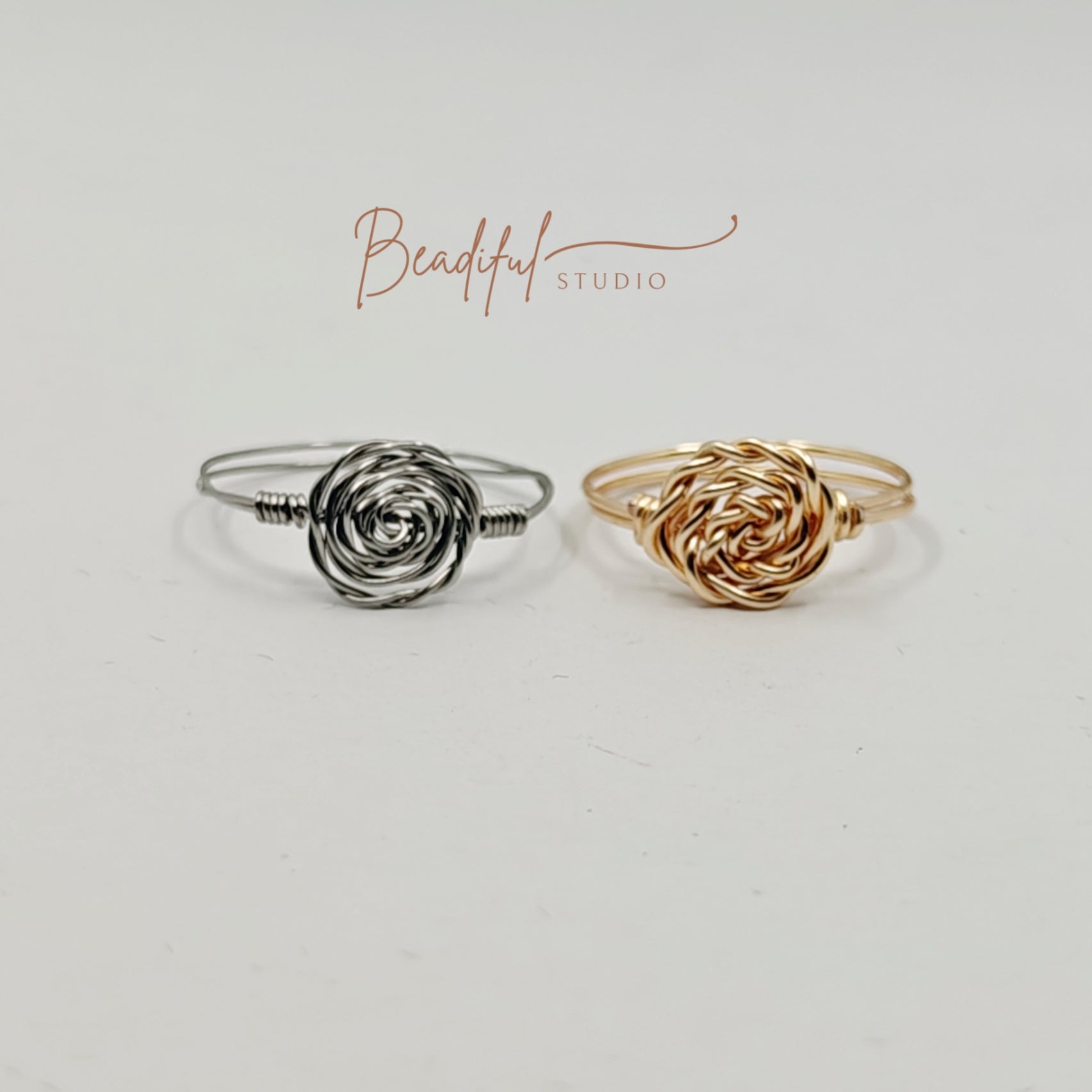 Picture with the store logo, and two wire wrapped rose rings, one in silver color and one in gold color.