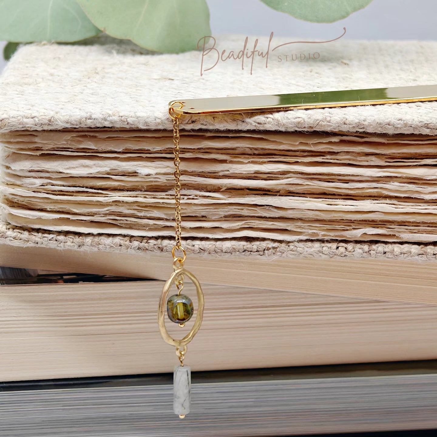 Image of the Aria bookmark dangling off the side of a pile of stacked books.