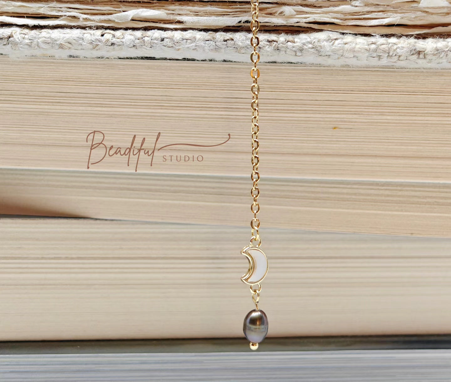 Image of the bookmark dangling from the side of a pile of stacked books.