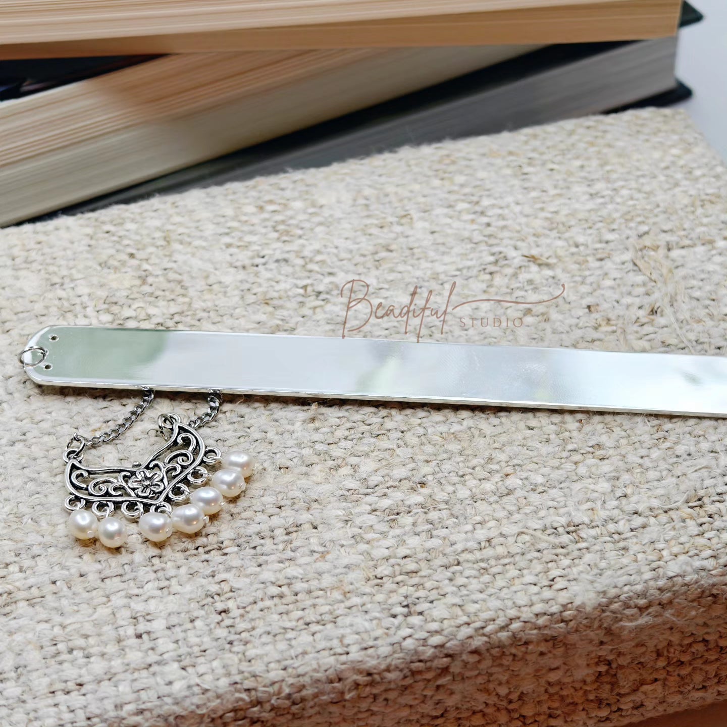 Image of the Serafina bookmark that has a silver toned bar. It features an antique silver color connector with seven white cultured freshwater pearls.